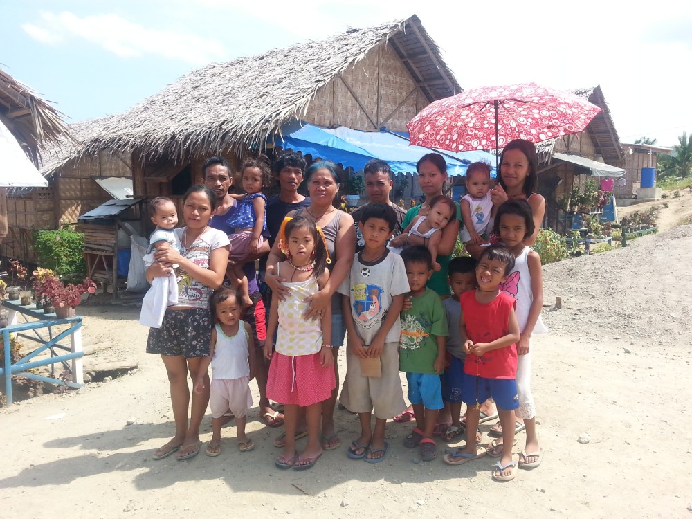 A family of three squeezes inside a nipa transitional house