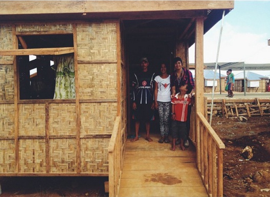 Charlie, Bienvenida and their son Crisanto see their new coco lumber home for the first time. Taken November 2013 in Guiuan, Eastern Samar. (Photo by Lian Buan)