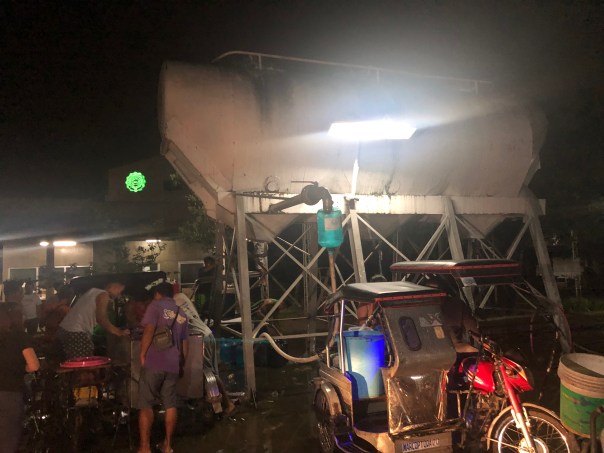 Antipolo residents line up well past midnight to seek water from a deep well. Large containers cost P40 each.